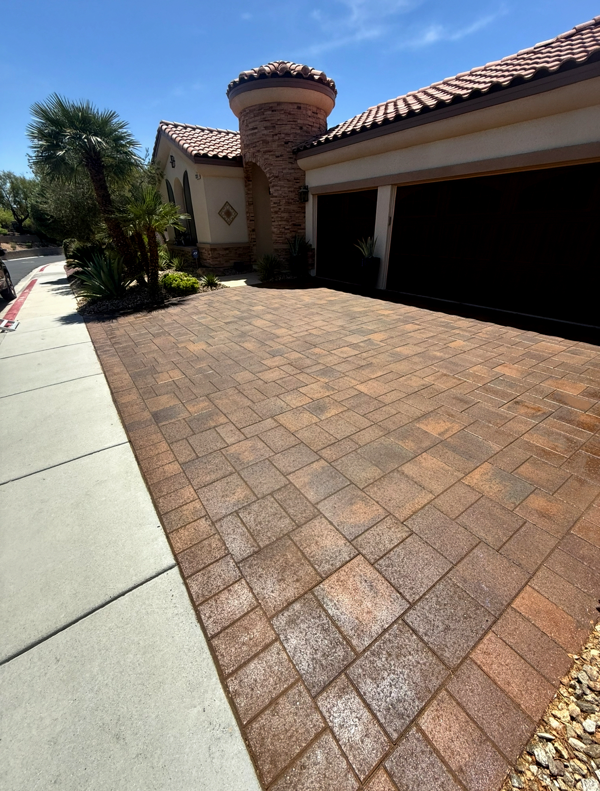 Freshly sealed paver driveway showing rich color and a glossy finish at a residential home in Las Vegas and Henderson.